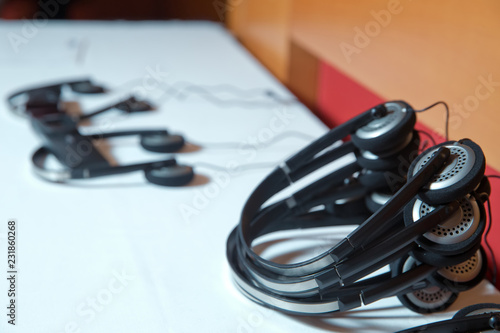 A set of headphones for simultaneous translation during negotiations in foreign languages . wireless multy language headphones set on the chairs in conference room