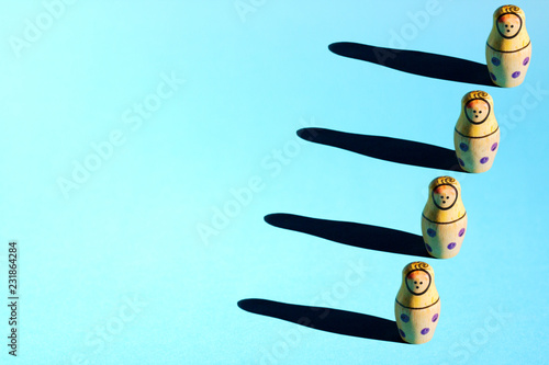 Obraz na plátně Row of nesting dolls with hard shadows on background