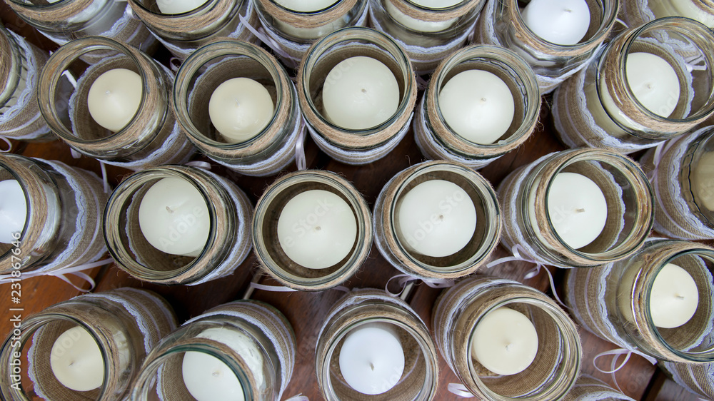 Wedding decoration - candles in glass jars decorated with lace, sackcloth and ribbons - flat lay top-down composition Wedding decoration - candles in glass jars decorated with lace, sackcloth and ribbons - flat lay top-down composition