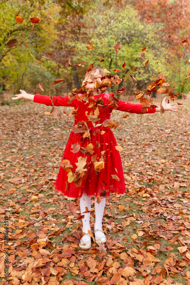 Girl with red dress in autumn park throwing leaves 1 Girl with red dress in autumn park throwing leaves 1