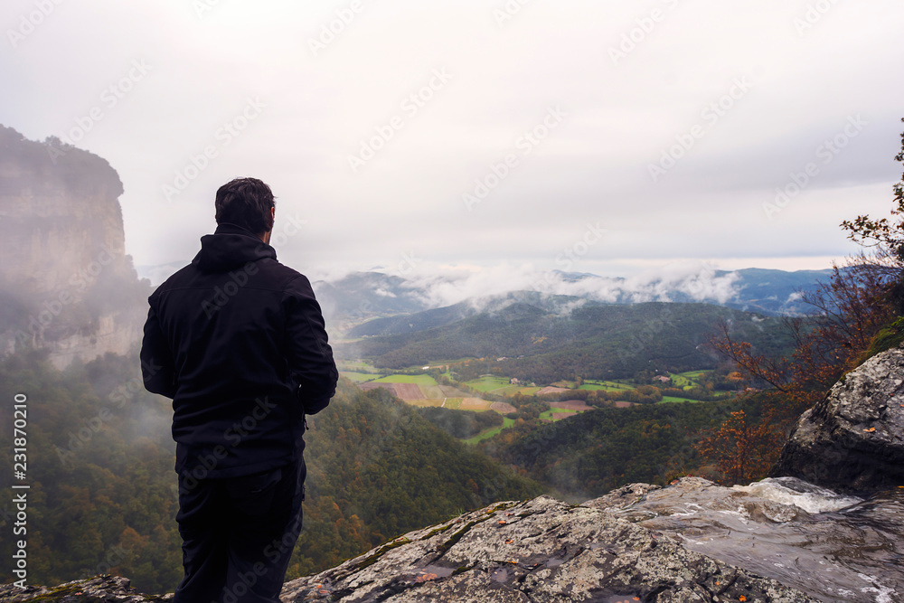 man looking at the horizon from a cliff