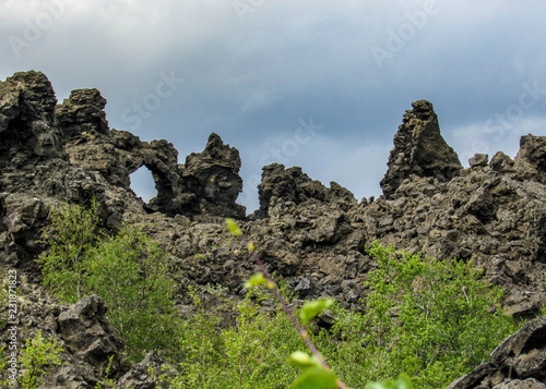 Dramatic black lava rock structures, unique volcanic flow formations and green Icelandic forest, Myvatn area, Northern Iceland, Europe.