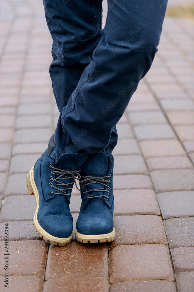 Blue boots on men's legs in blue jeans Blue boots on men's legs in blue jeans