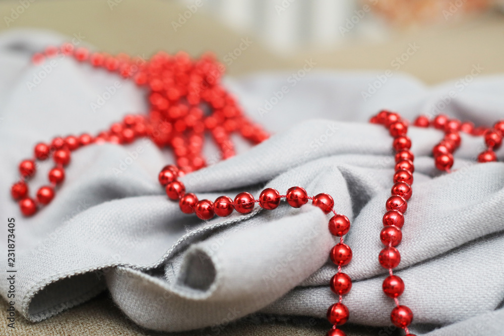 Christmas garland of small red beads on a gray wool fabric. Christmas garland of small red beads on a gray wool fabric.