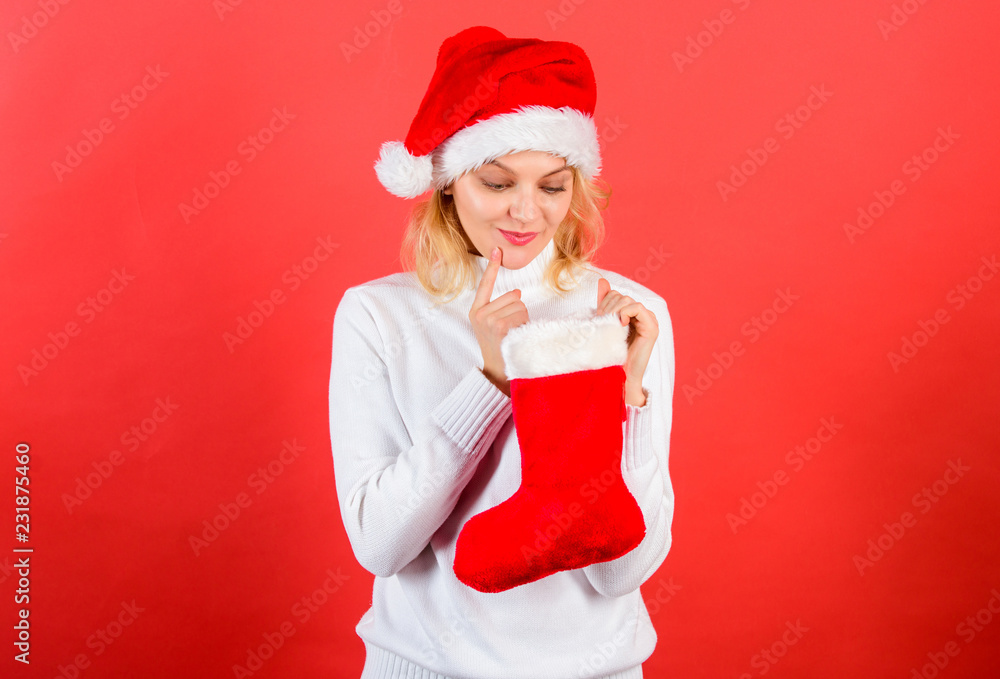 Check contents of christmas stocking what she received. Woman in santa hat unpacking christmas gift red background. Christmas stocking concept. Girl cheerful face check out gift in christmas sock Check contents of christmas stocking what she received. Woman in santa hat unpacking christmas gift red background. Christmas stocking concept. Girl cheerful face check out gift in christmas sock