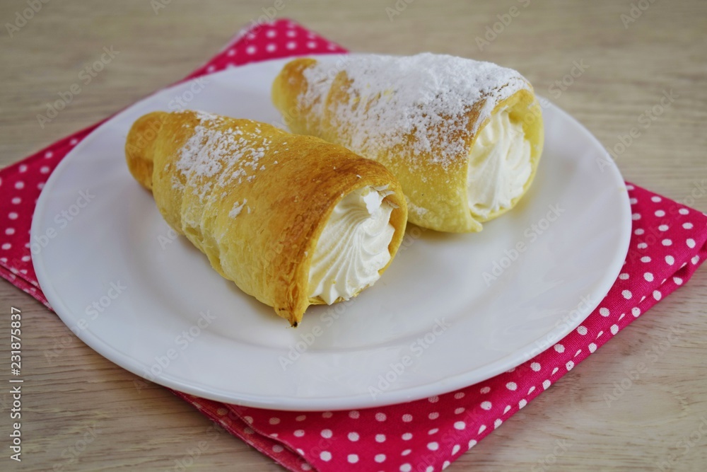 Delicious puff pastry cakes with protein cream on a white plate. Delicious puff pastry cakes with protein cream on a white plate.