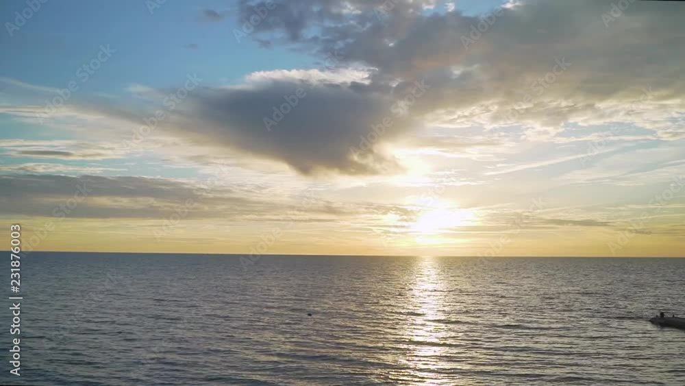 Sunset over the lake with a clear sky and a beautiful color overflow from orange to blue on the water. Sunset over the lake with a clear sky and a beautiful color overflow from orange to blue on the water.