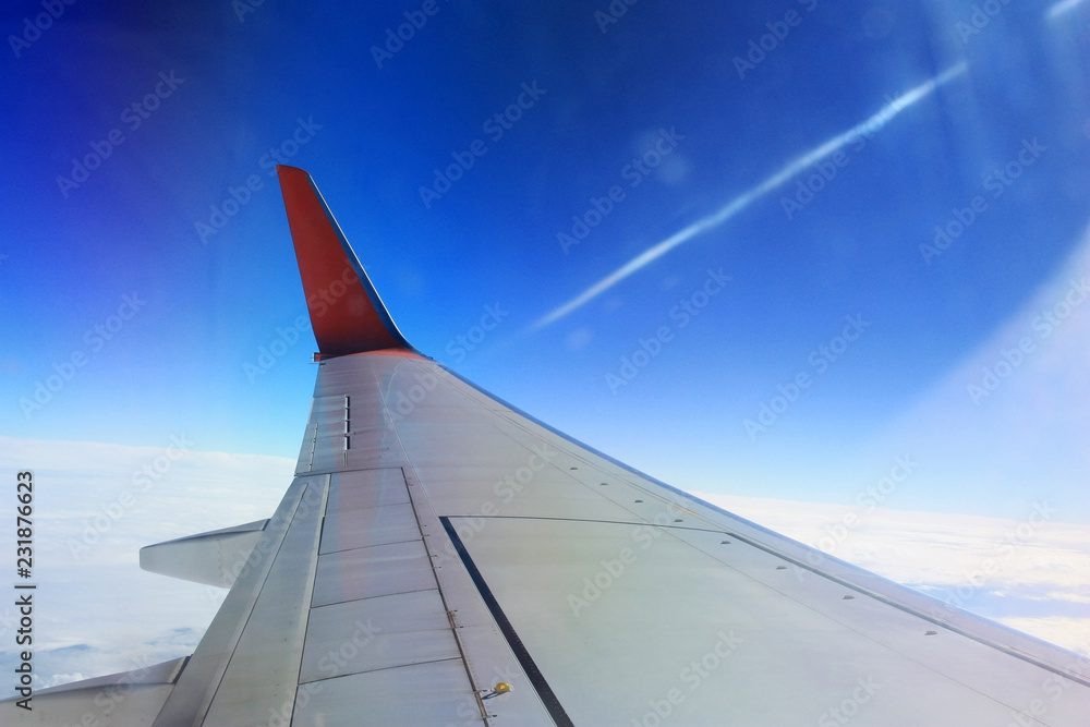 wing of airplane flying above clouds