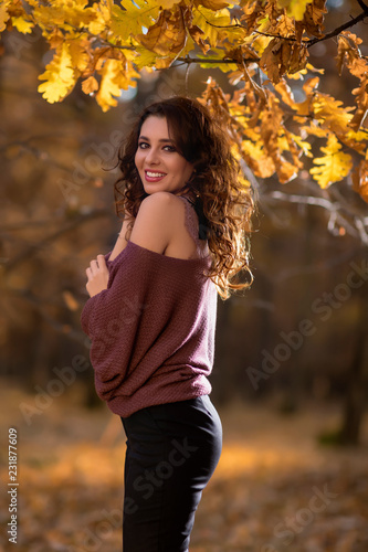 A portrait of a beautiful young woman in an autumn forest. Lifestyle, autumn fashion, beauty.