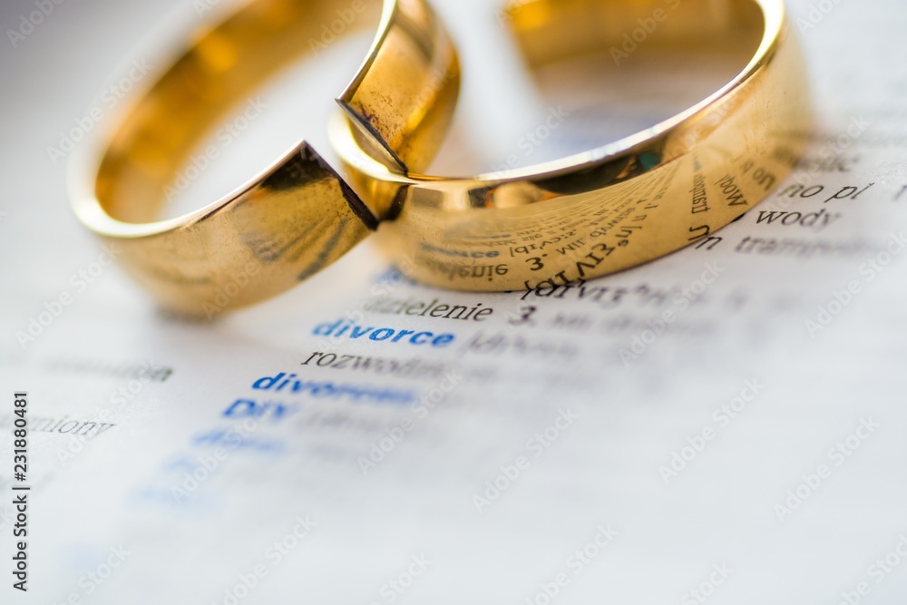 Two Broken Rings Two broken wedding rings on divorce word in dictionary. Stock Photo ...
