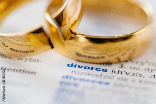 Obraz na płótnie Two broken wedding rings on divorce word in dictionary. w salonie