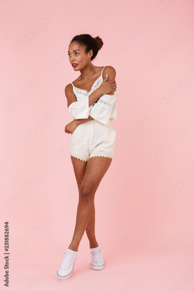 Beautiful young african woman isolated over pink backgroung wall looking aside. Beautiful young african woman isolated over pink backgroung wall looking aside.