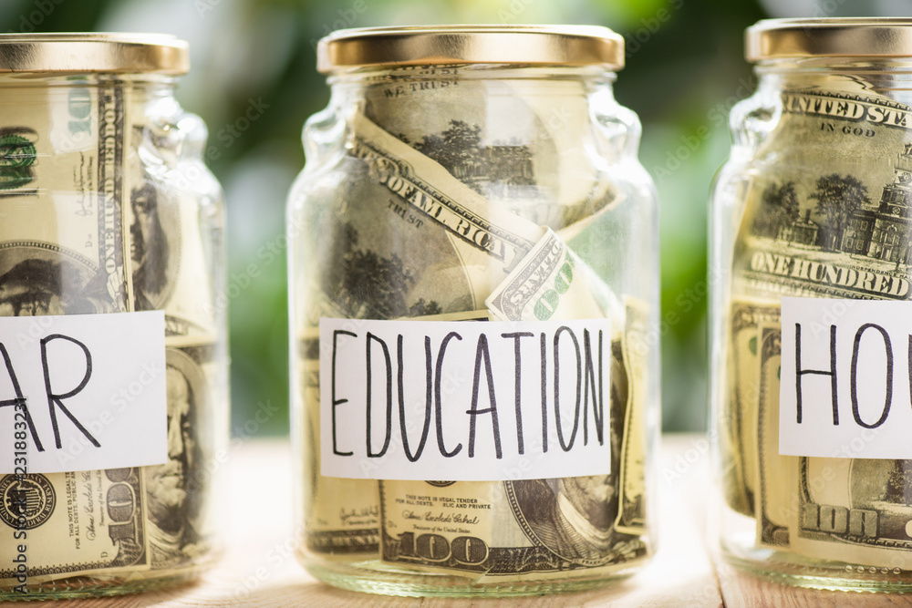 Glass jars with dollar banknotes and inscriptions car, education, house Glass jars with dollar banknotes and inscriptions car, education, house
