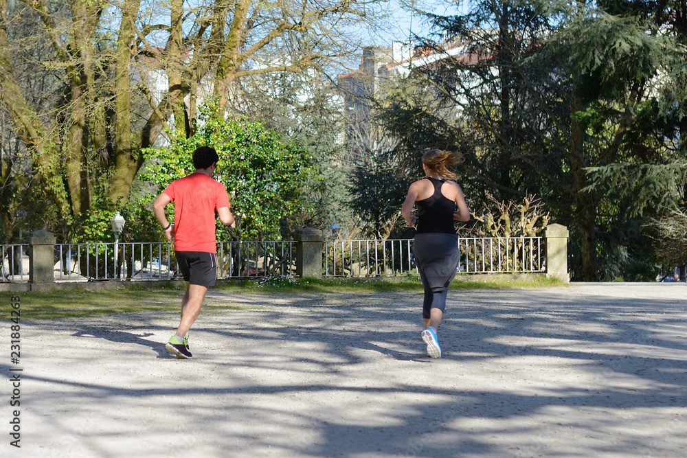 young man and woman jogging in a city park young man and woman jogging in a city park