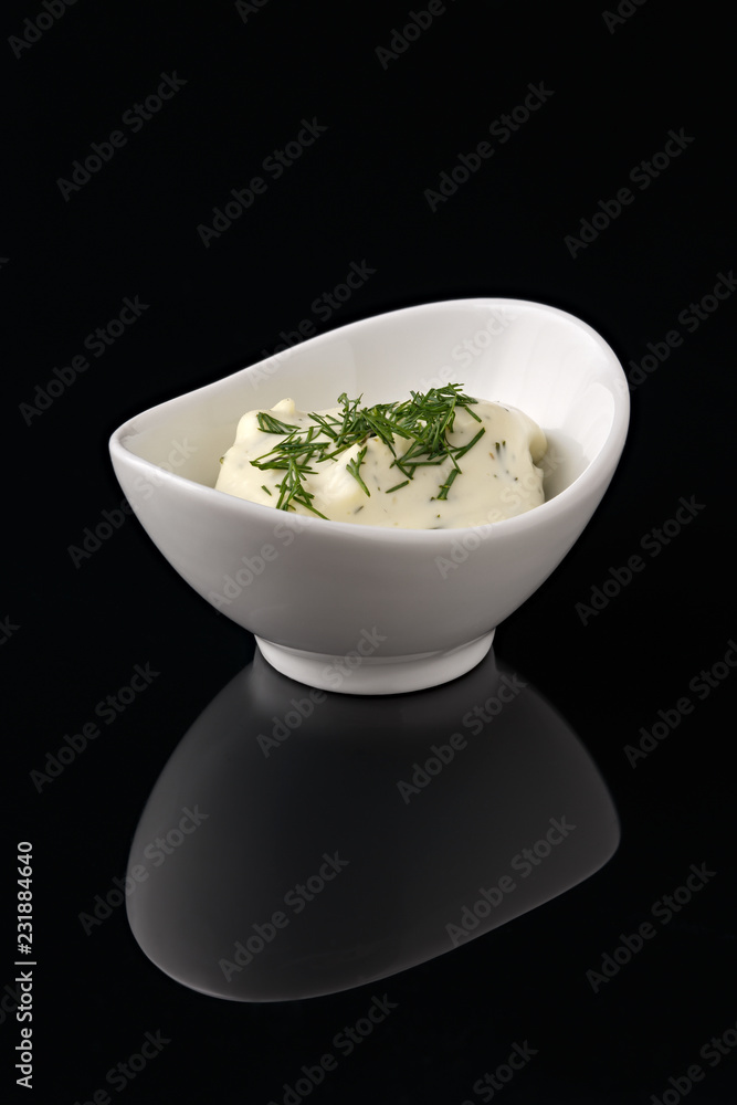 Sauce in a white bowl on a black background with reflection. Sauce in a white bowl on a black background with reflection.