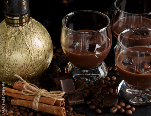 Chocolate, coffee, creamy liqueur, cocktail with coffee beans, chocolate and cinnamon. On a black background. Christmas alcoholic drink