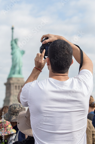 Wallpaper Mural man taking photo on statue of liberty Torontodigital.ca