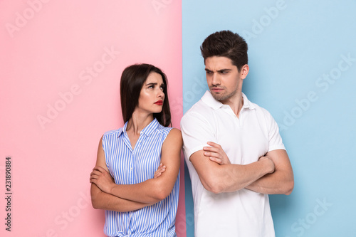 Fotografía Photo of resentful man and woman in casual clothes standing with arms folded in