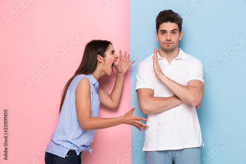 Fototapete Photo of crazy woman in casual clothes yelling at man standing face to face, iso