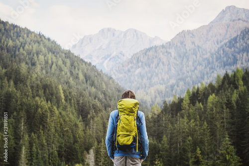 Young backpacking man traveler enjoying nature in Alps mountains. Travel and active lifestyle concept.