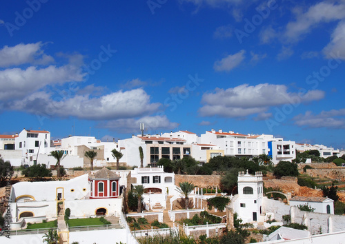 Panoramic cityscape view of white houses in ciutadella menorca against a blue sky