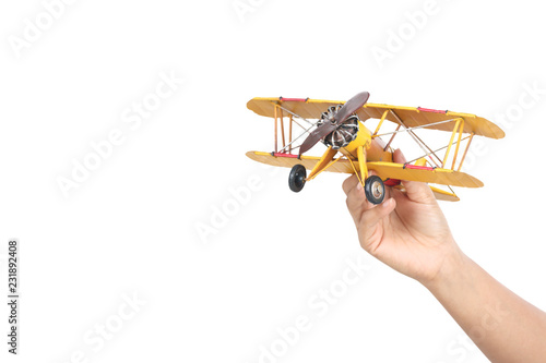 hand holding toy airplane, isolated on white background