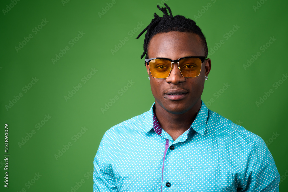 Young handsome African man from Kenya against green background Young handsome African man from Kenya against green background