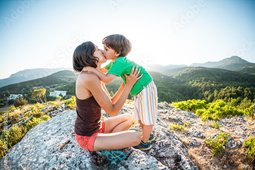 A woman with a child is sitting on top of a mountain.