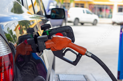 fuel nozzle. Filling gasoline to black car at gas station