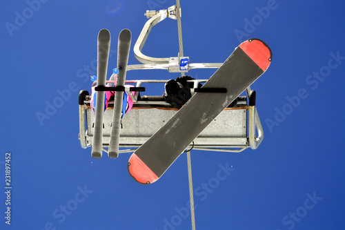 Skier and snowboarder are on the mountain  lift go to the top of the mountain to go down the slopes.