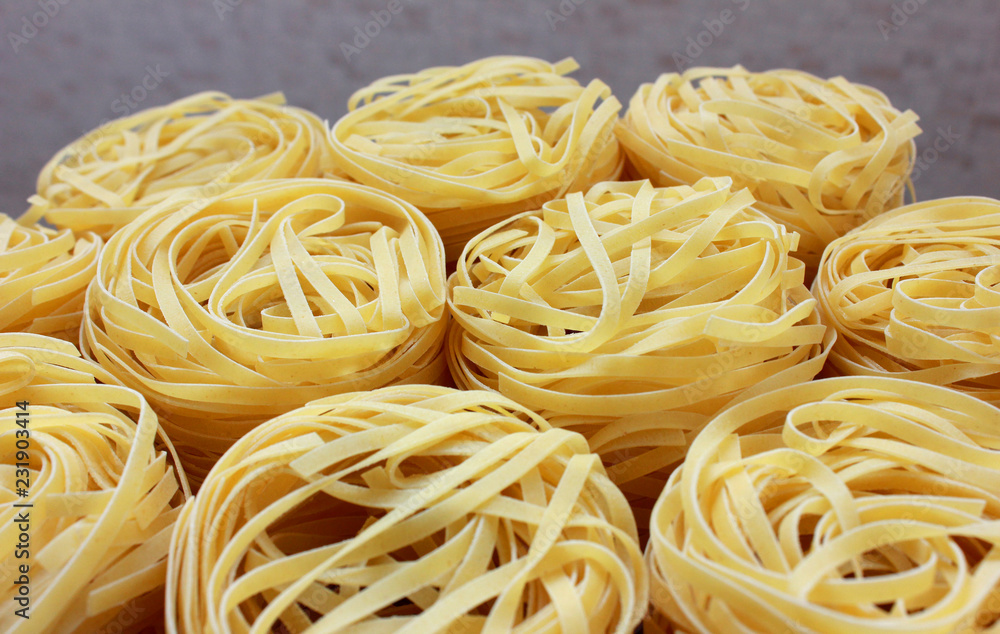 nests of pasta on gray background nests of pasta on gray background