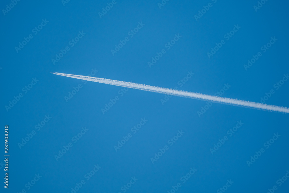 Trail from an airplane in the blue sky Trail from an airplane in the blue sky