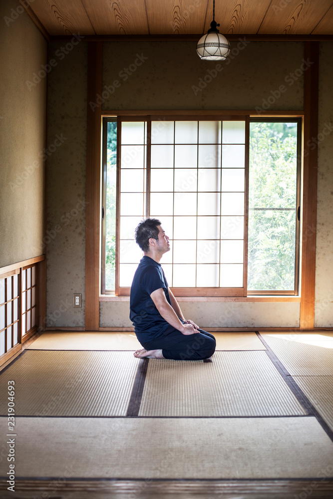 Japanese man kneeling on tatami mat in traditional Japanese house. Stock Photo Adobe Stock