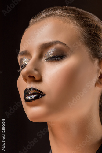 young beautiful woman with glittery makeup and closed eyes