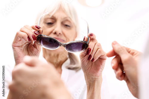 Ochrona oczu przed słońcem, okulary przeciwsłoneczne z filtrem.Starsza kobieta kupuje okulary przeciwsłoneczne