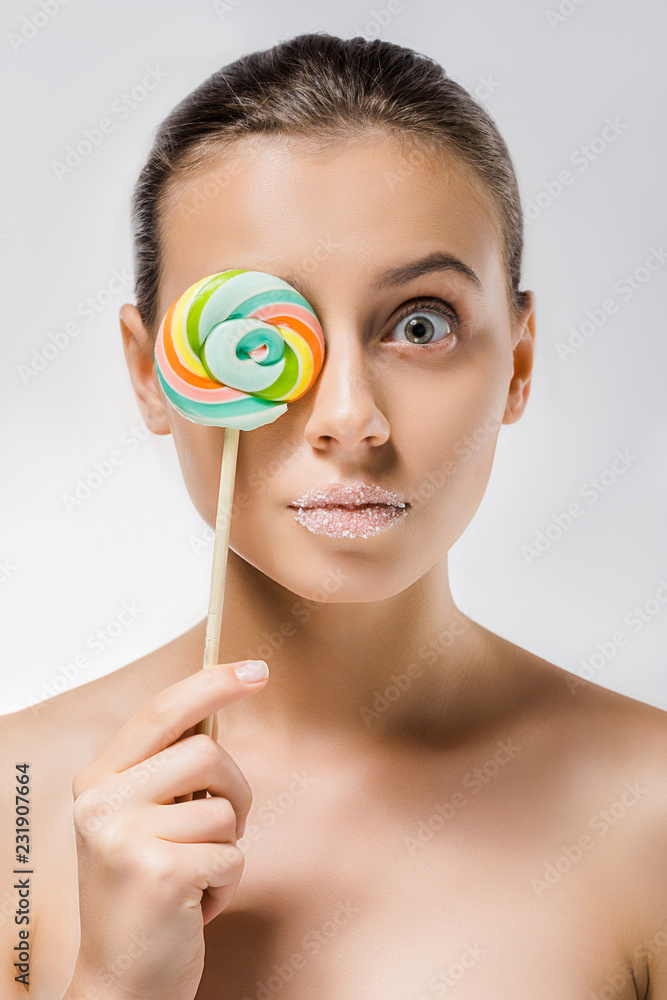 young attractive woman with sugar on lips hiding behind colored lollipop