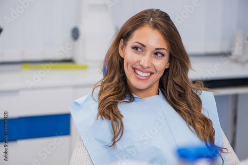Young female patient talking with her dentist