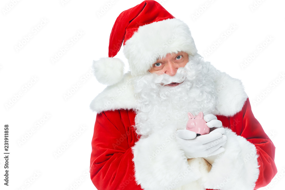 santa claus holding little piggy bank and looking at camera isolated on white santa claus holding little piggy bank and looking at camera isolated on white