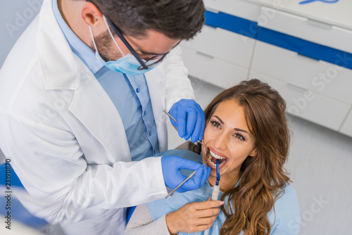 Professional handsome dentist examining teeth