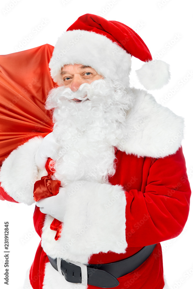 smiling santa claus carrying red christmas bag isolated on white
