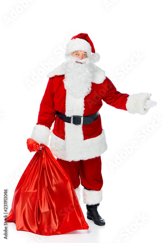 santa claus with red christmas bag showing something isolated on white