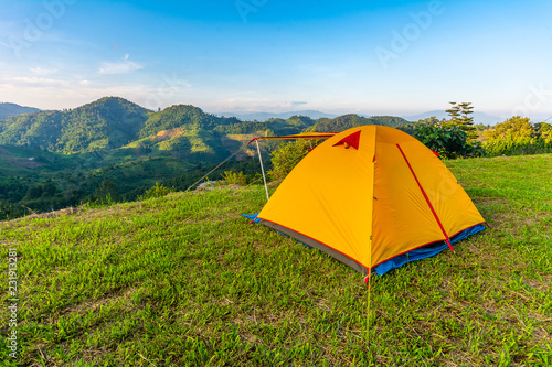 Camping orange tent on the mountain during sunrise in Chiang Rai, Thailand.