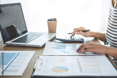 Female accountant calculations, audit and analyzing financial graph data with calculator and laptop Business, Financing, Accounting, Doing finance, Economy, Savings Banking Concept