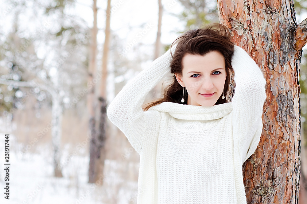 portrait of a girl with dark hair and a white jacket on the background of a snow Park portrait of a girl with dark hair and a white jacket on the background of a snow Park