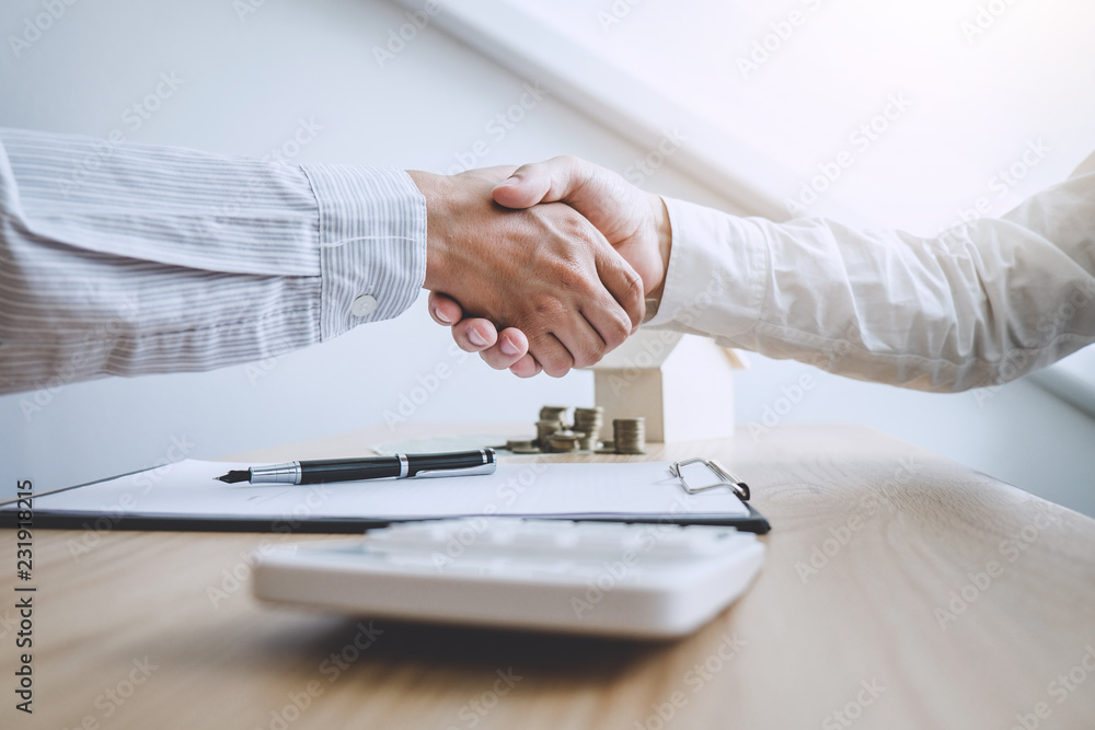 Fototapeta premium Real estate broker agent and customer shaking hands after signing contract documents for ownership realty purchase, Concept mortgage loan approval
