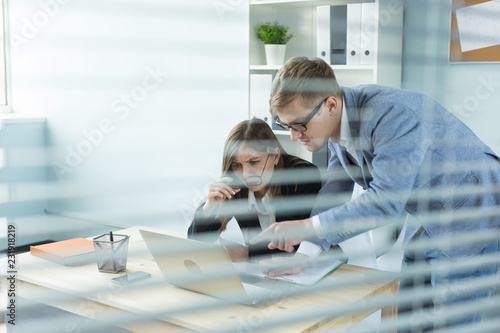Business, teamwork and people concept - Portrait of serious man and attractive woman working at project in office.