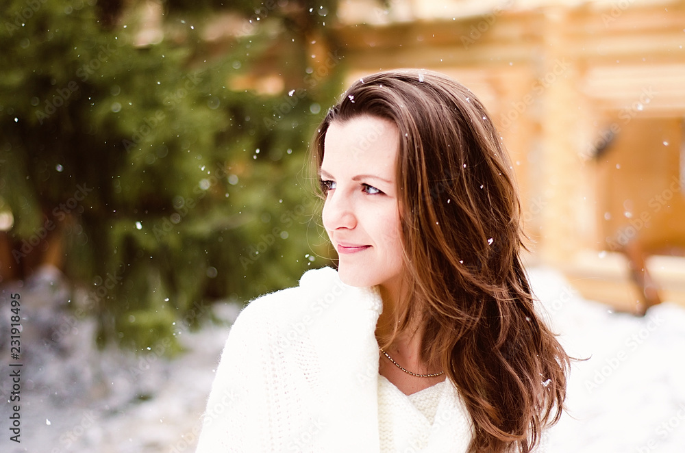 Obraz premium portrait of a girl with dark hair and a white jacket on the background of a snow Park