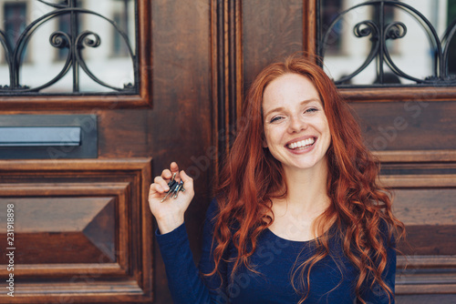Grinning woman holding keys in closed hand