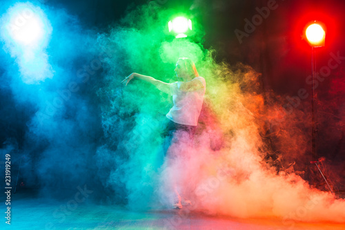 Modern dance concept - Cheerleading young woman dancing on coloured background