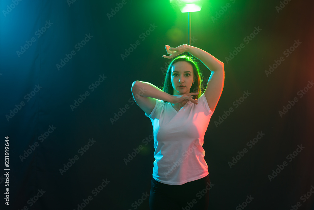 Young athletic female dancing street dance in studio